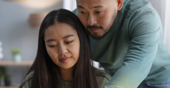 parent helping student do schoolwork on laptop